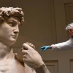 An art restorer works on cleaning Michelangelo's David, one of the world's most famous statues, on February 29, 2016 at the Galleria dell'Accademia in Florence