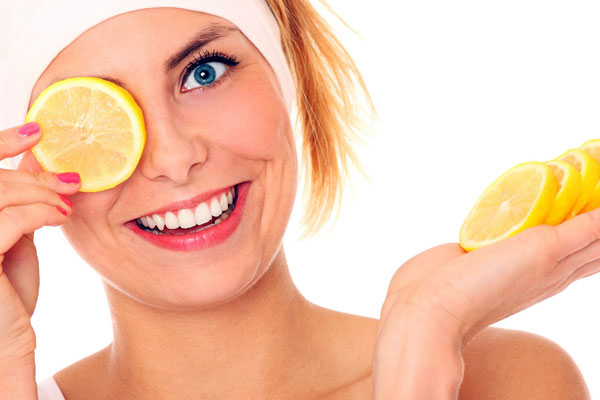 woman smiling with a slice of lemon