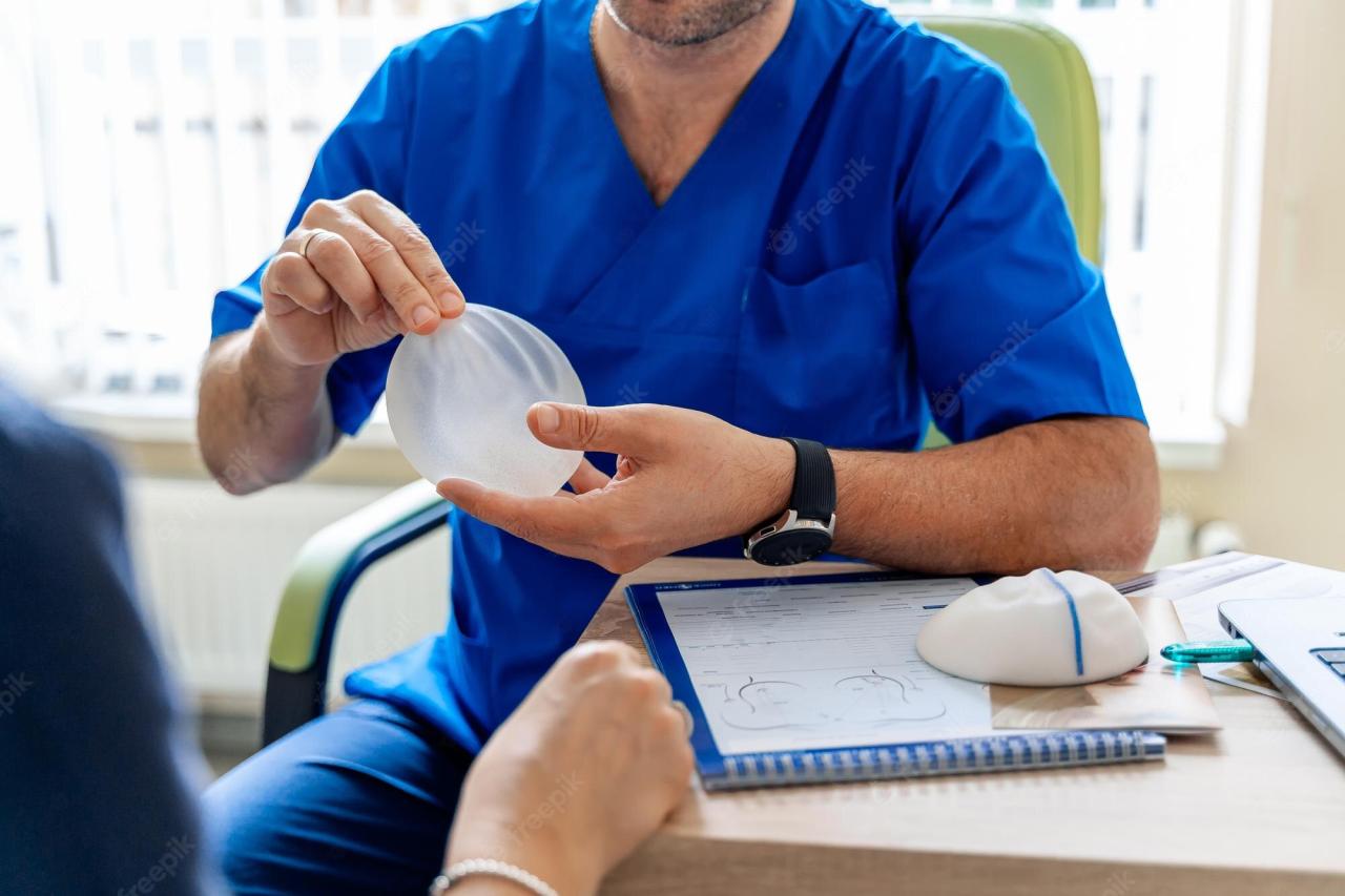 doctor holding breast implants