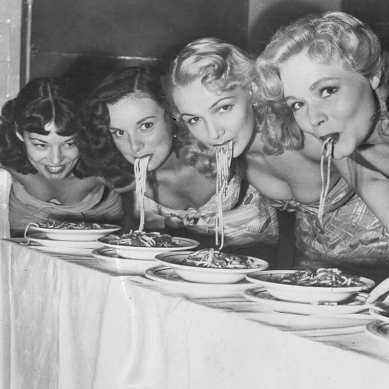 women eating spaghetti