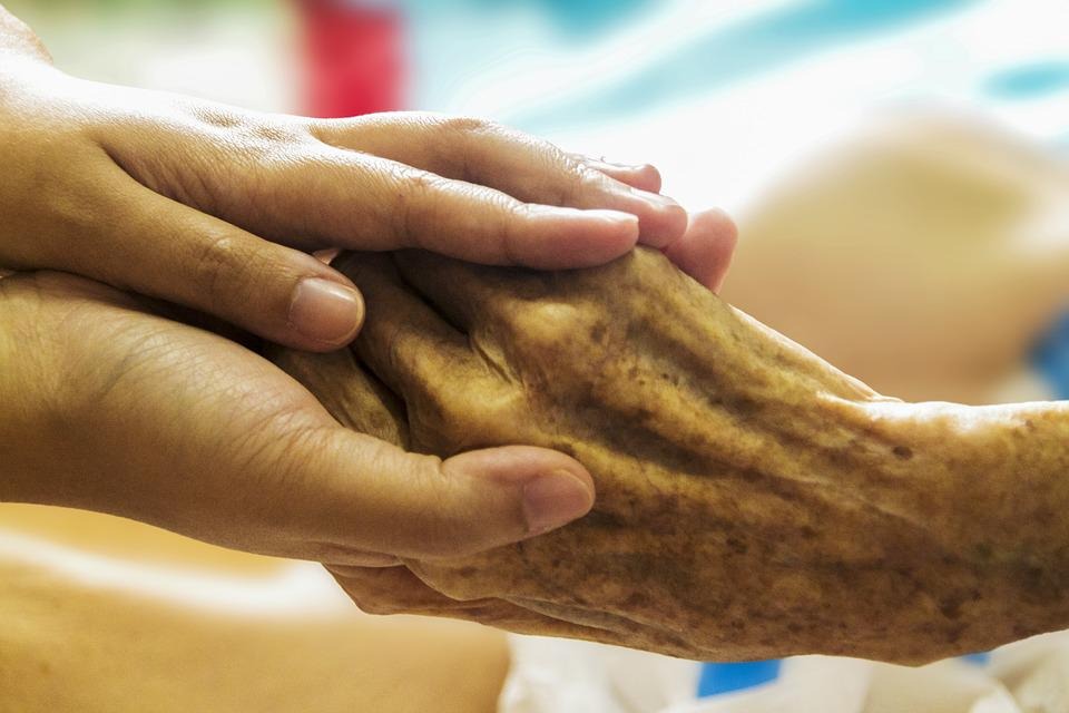 Sostiendo la mano de una anciana