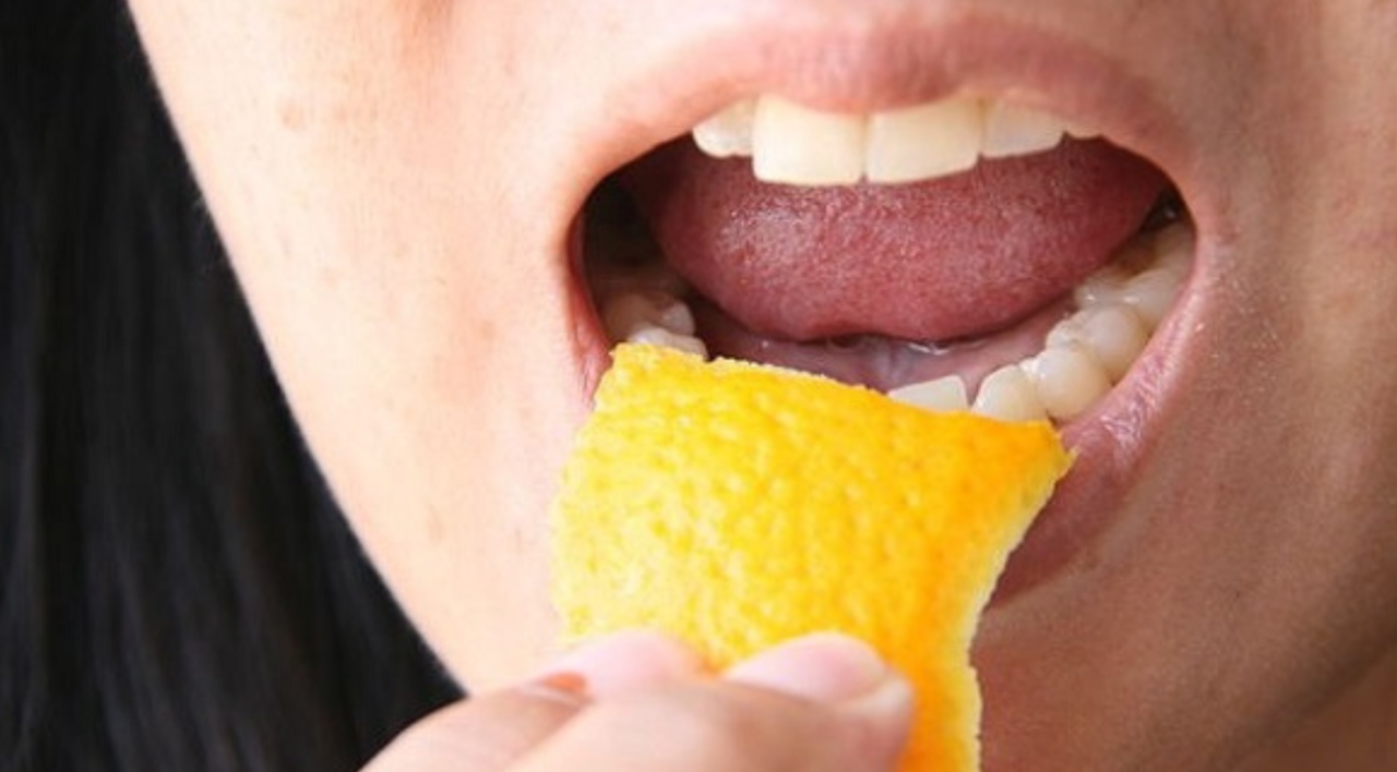 woman eating an orange skin